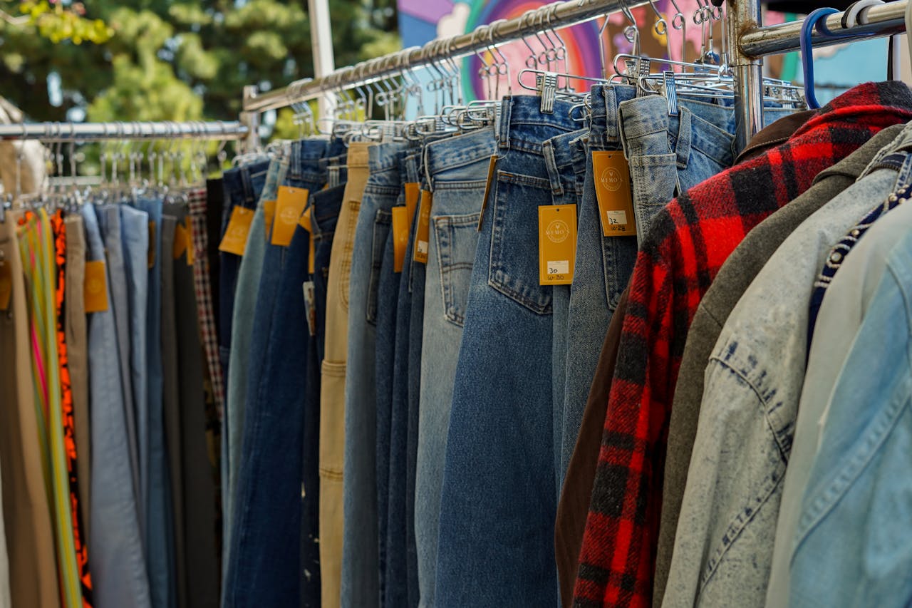 A rack of vintage jeans and shirts at an outdoor flea market in Los Angeles, CA.